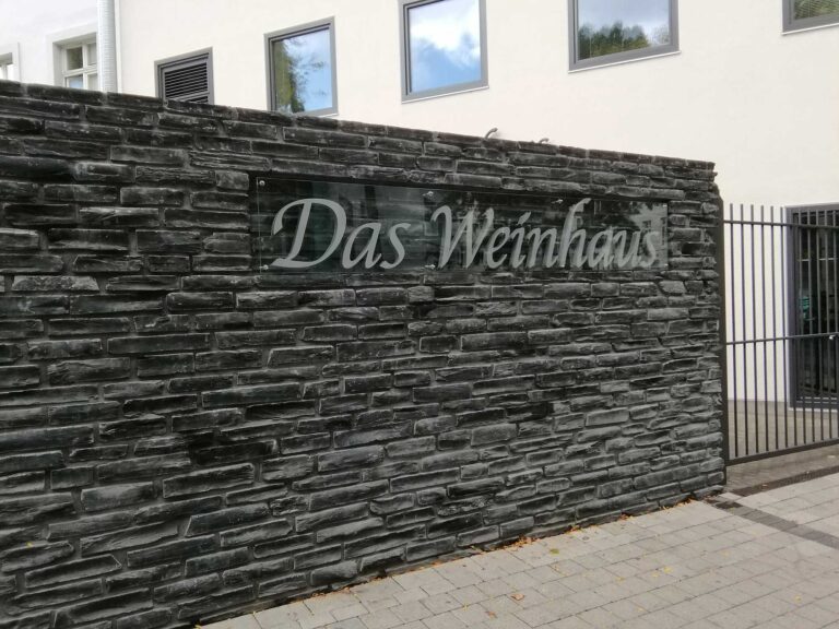 Schild mit Fräsbuchstaben für Das Weinhaus
